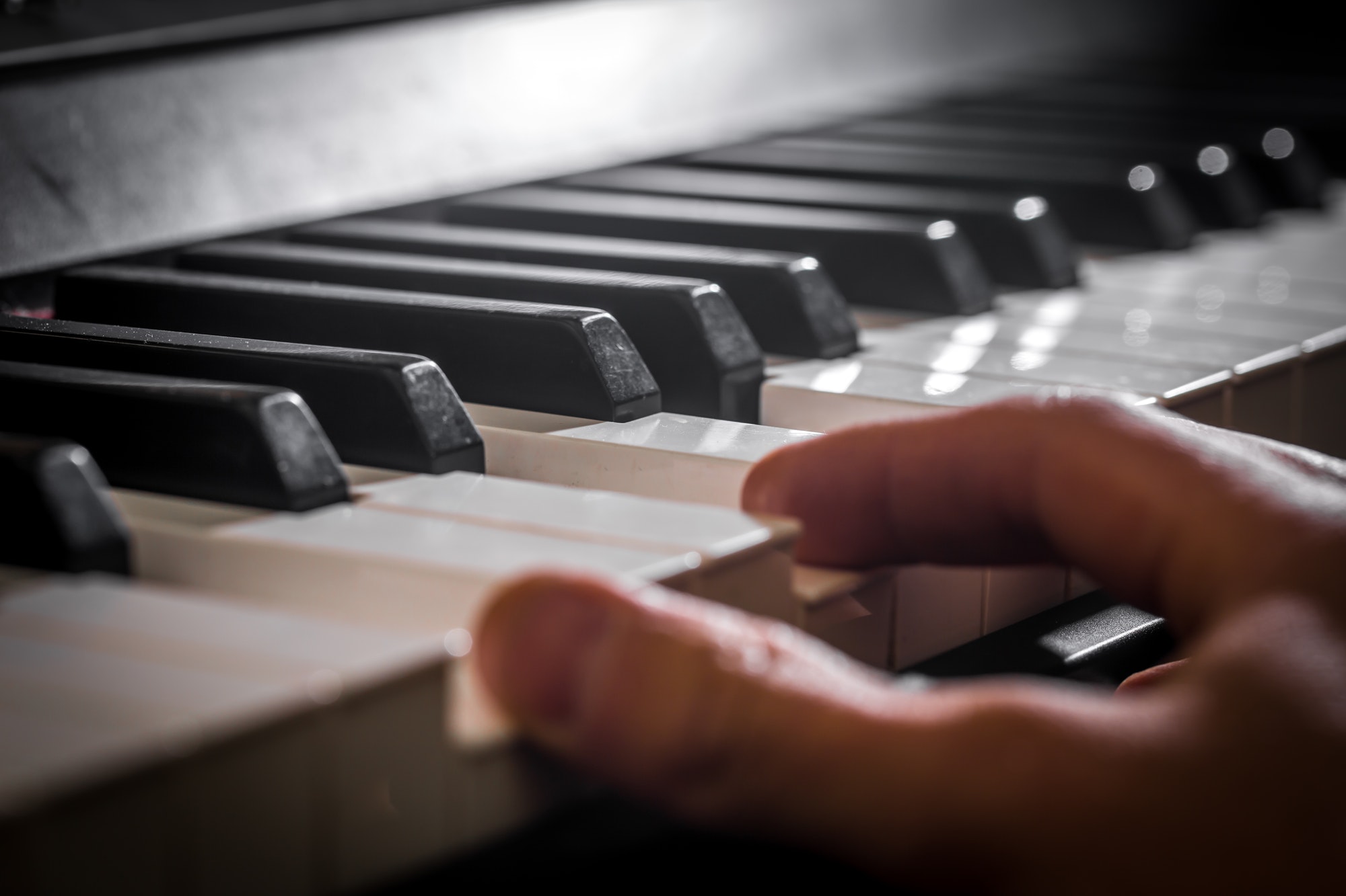 The piano and the pianist's hands. Details of the musical instrument.